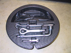 Spare tire kit for 2009 through 2012 Infiniti G37 convertibles image showing close up of accessory kit with tow hook